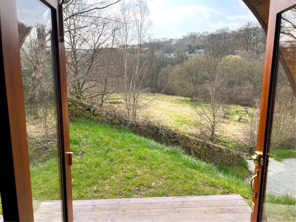 The view out through a pod's double doors, across the field to the valley