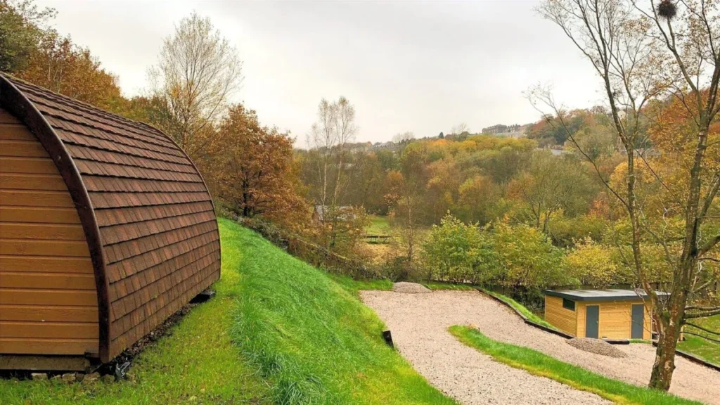A cedar-shingled glamping pod looking out over the Ryburn valley in autumn