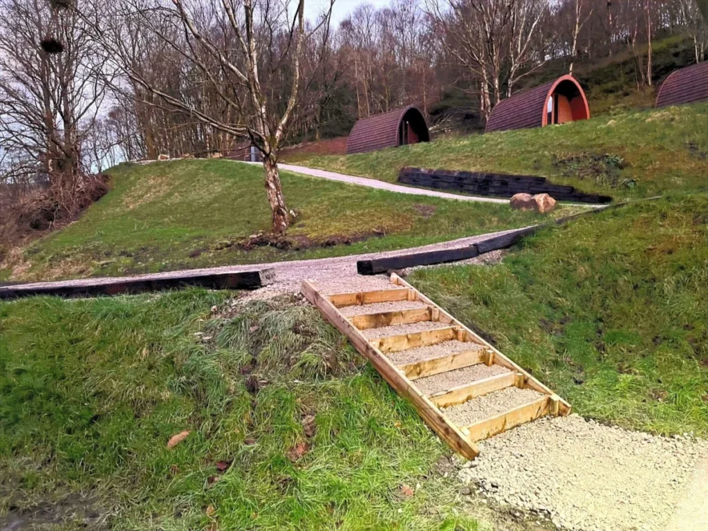 The boardwalk and timber steps up the bank to the glamping pods