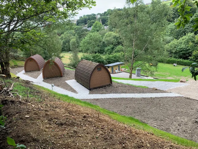 Glamping pods on the newly landscaped bank at Riverside, with gravel paths